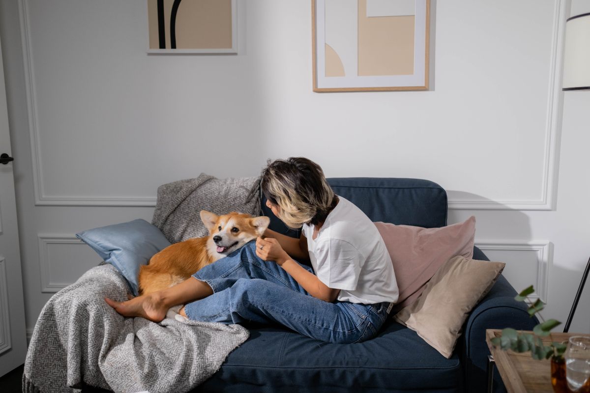 Woman sitting on the couch beside the dog